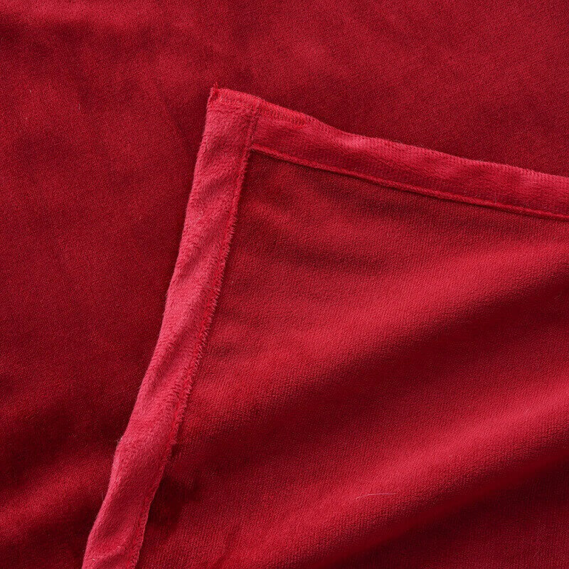Closeup of a red seamless minky fleece blanket showcasing durable edge stitching and ultra-soft fabric texture.