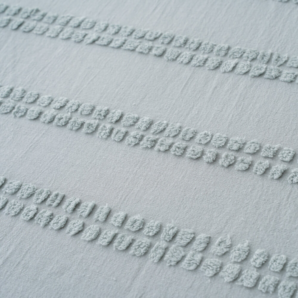 Macro texture detail of the tufted pattern on recycled cotton linen blend eco-friendly fabric.