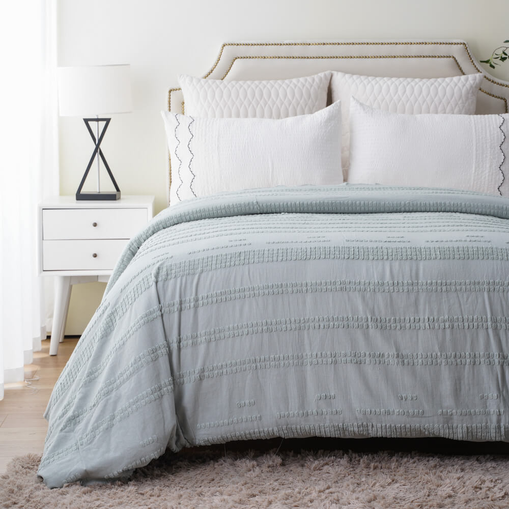 Light green sustainable cotton linen tufted duvet set styled in a cozy bedroom for wholesale buyers.