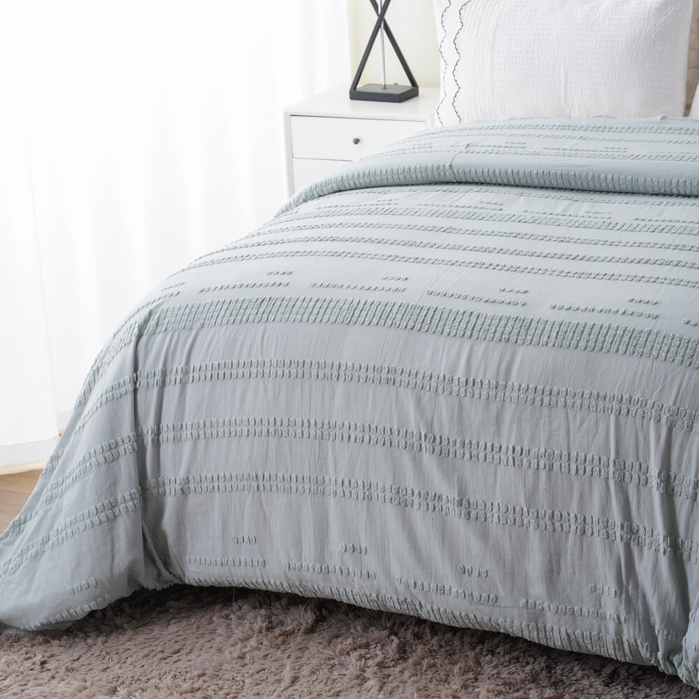 Tailored look and textured details of tufted cotton linen bedding set draped elegantly over a bed.
