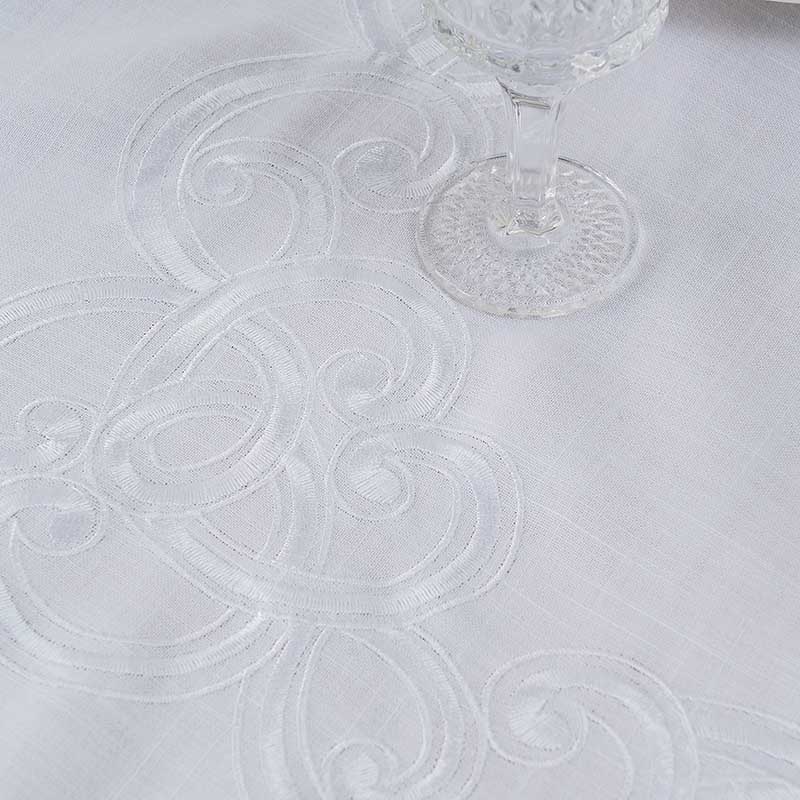 High-density elegant custom embroidery design on a white cotton polyester blend tablecloth