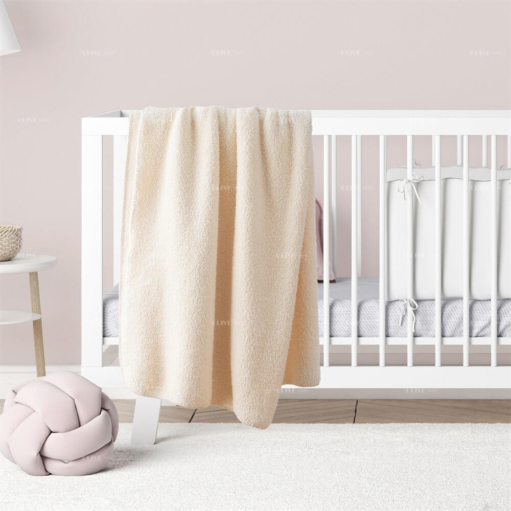 Soft microfiber chenille reversible baby blanket draped over a white wooden crib in a cozy nursery room.