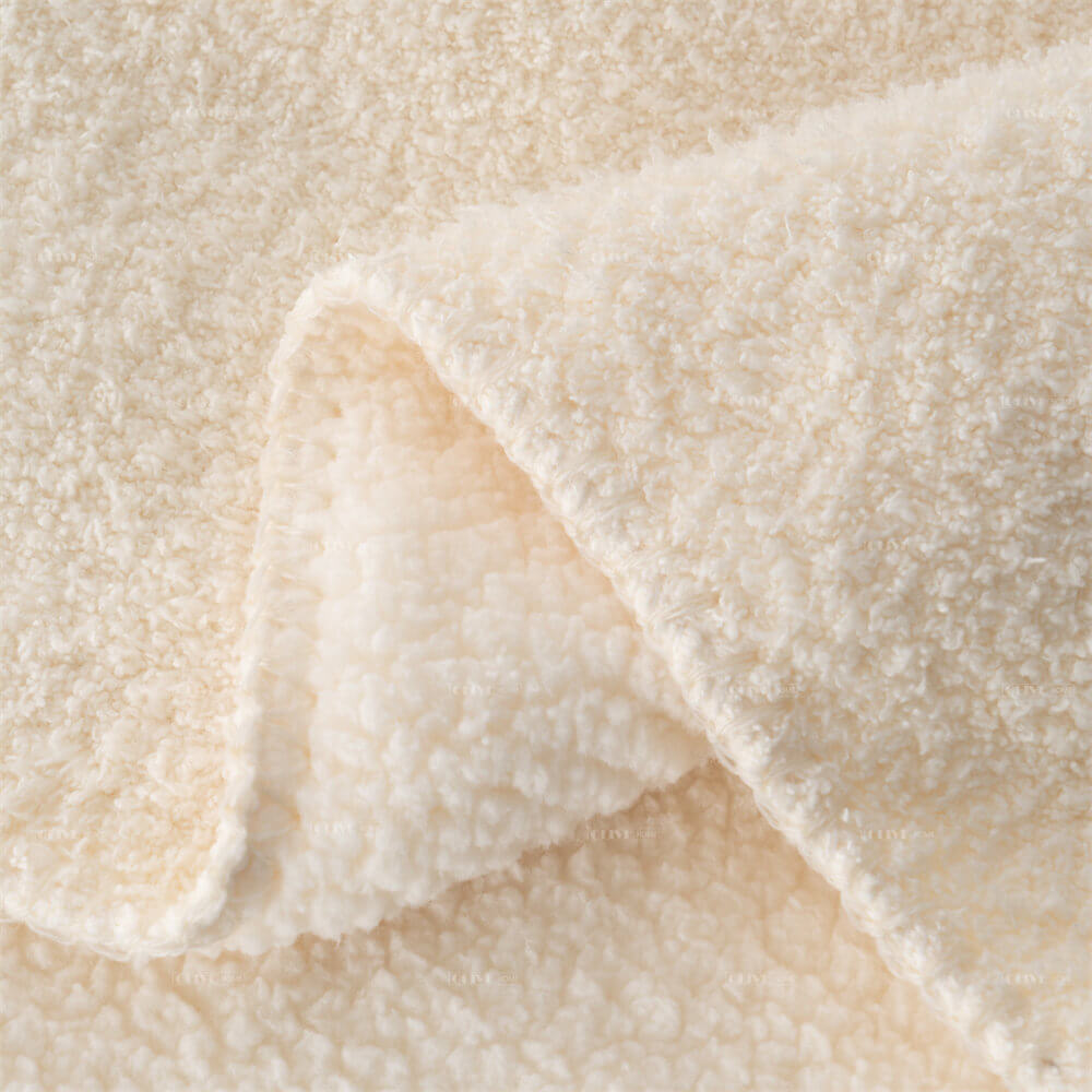 Close-up texture and neat stitching edge of cream microfiber chenille reversible throw blanket.