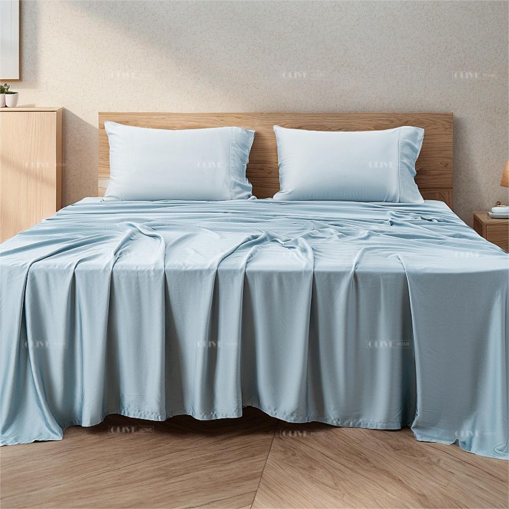 Full view of a luxury light blue organic bamboo cooling bed sheet set styled on a wooden bed, including matching pillowcases and sheets.