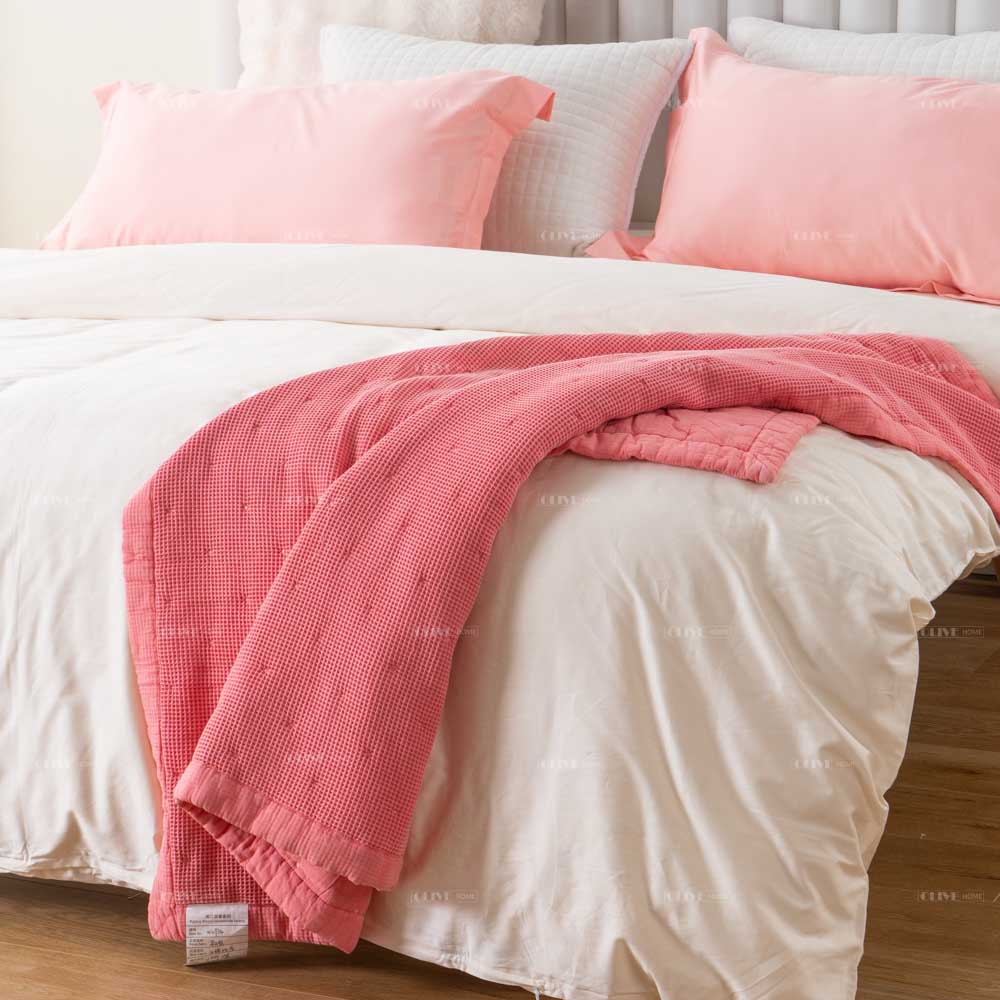 Mills waffle cotton quilt 4 Cozy Peachy Pink Mills waffle cotton quilt with dot quilting stitch detail and matching pillow shams displayed on a white bed
