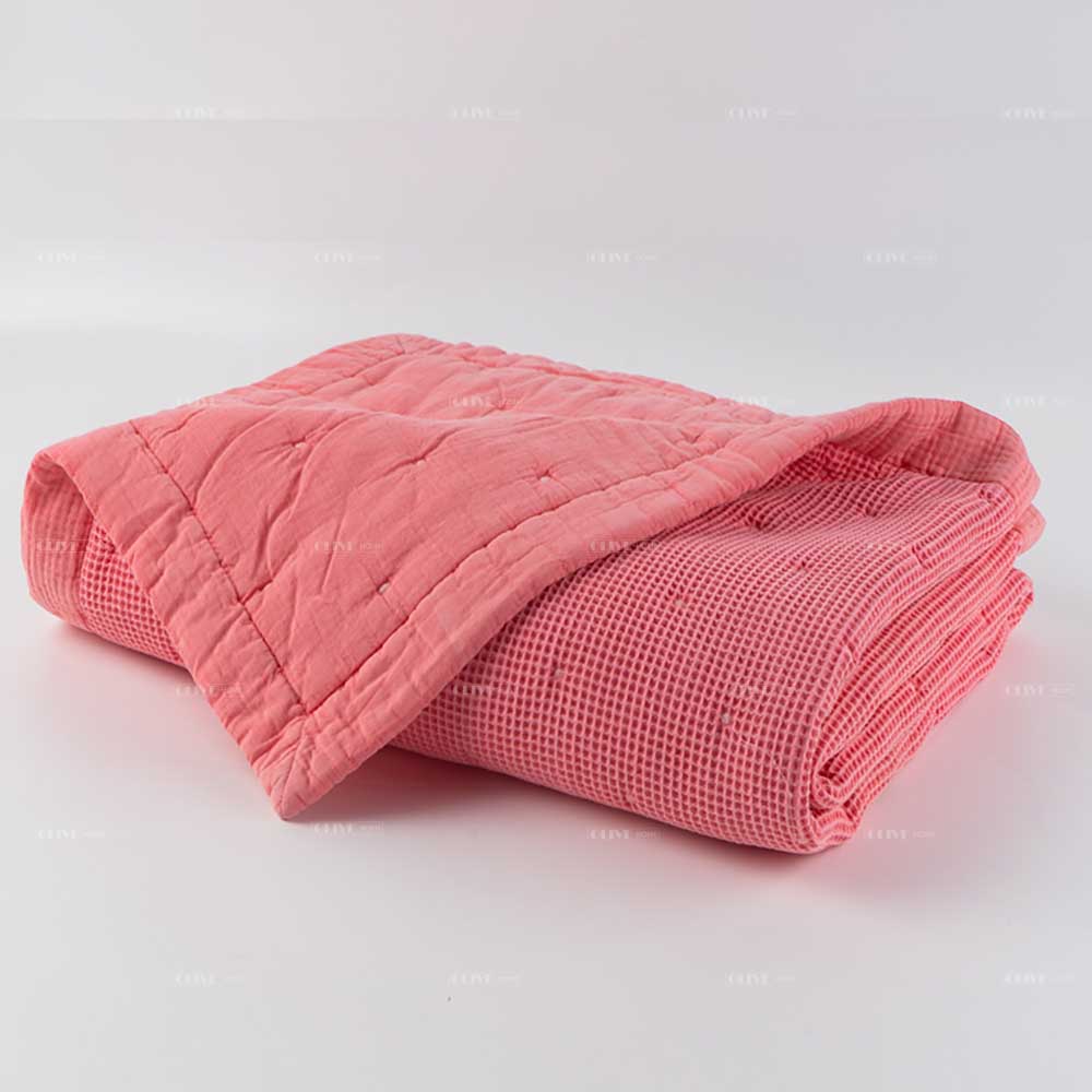 Mills waffle cotton quilt 9 Folded Peachy Pink Mills waffle cotton quilt showing reversible texture sides on a white background