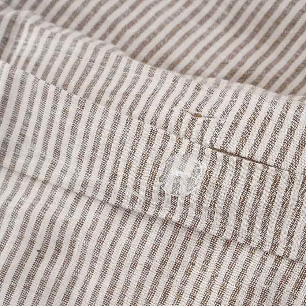 Hidden clear button closure details on a grey and white striped linen duvet cover, premium workmanship for luxury bedding brands.