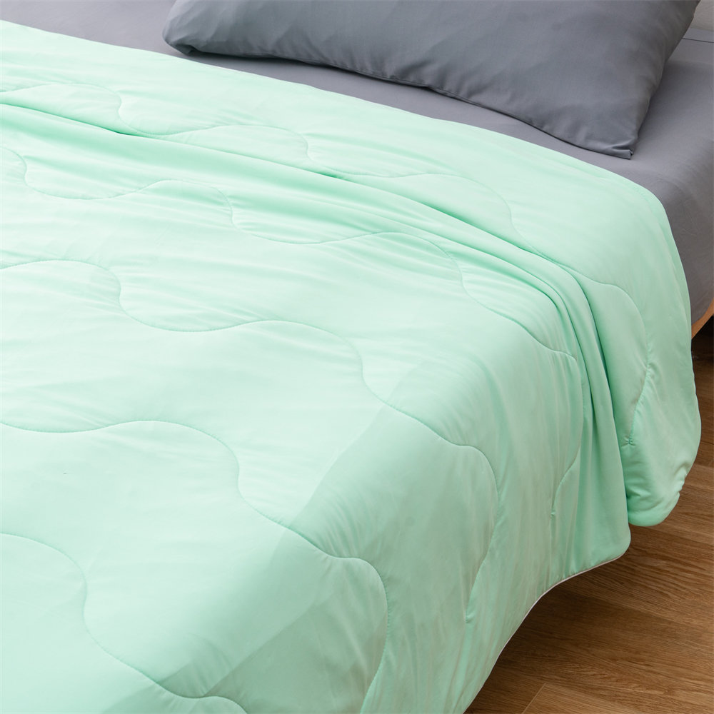 light weight cooling comforter 1 1 Close-up of mint green lightweight cooling comforter on a bed, premium custom stitching and cool-to-touch fabric for wholesale buyers