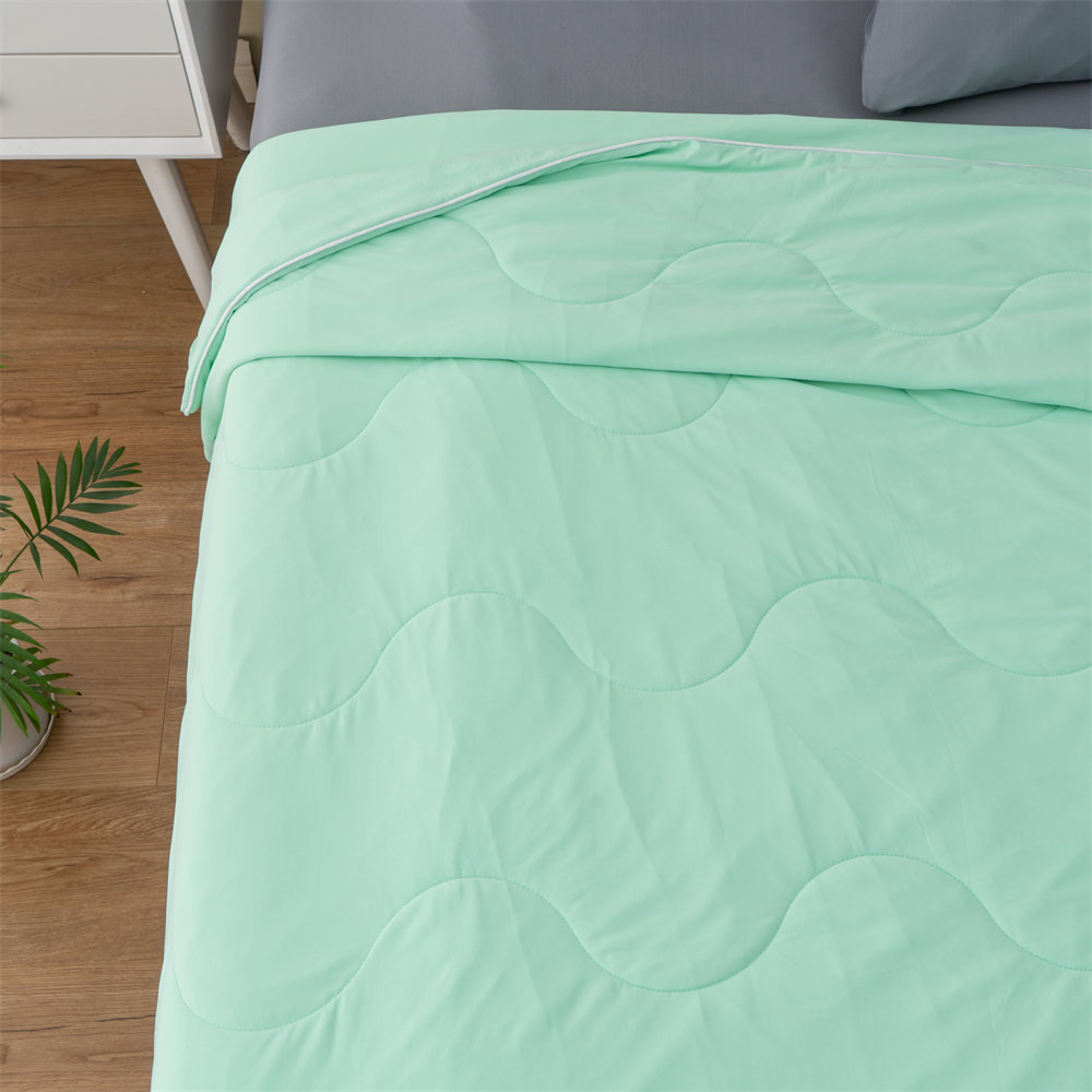 Premium mint green lightweight cooling comforter displayed in bedroom setup, customized bedding solutions for international distributors