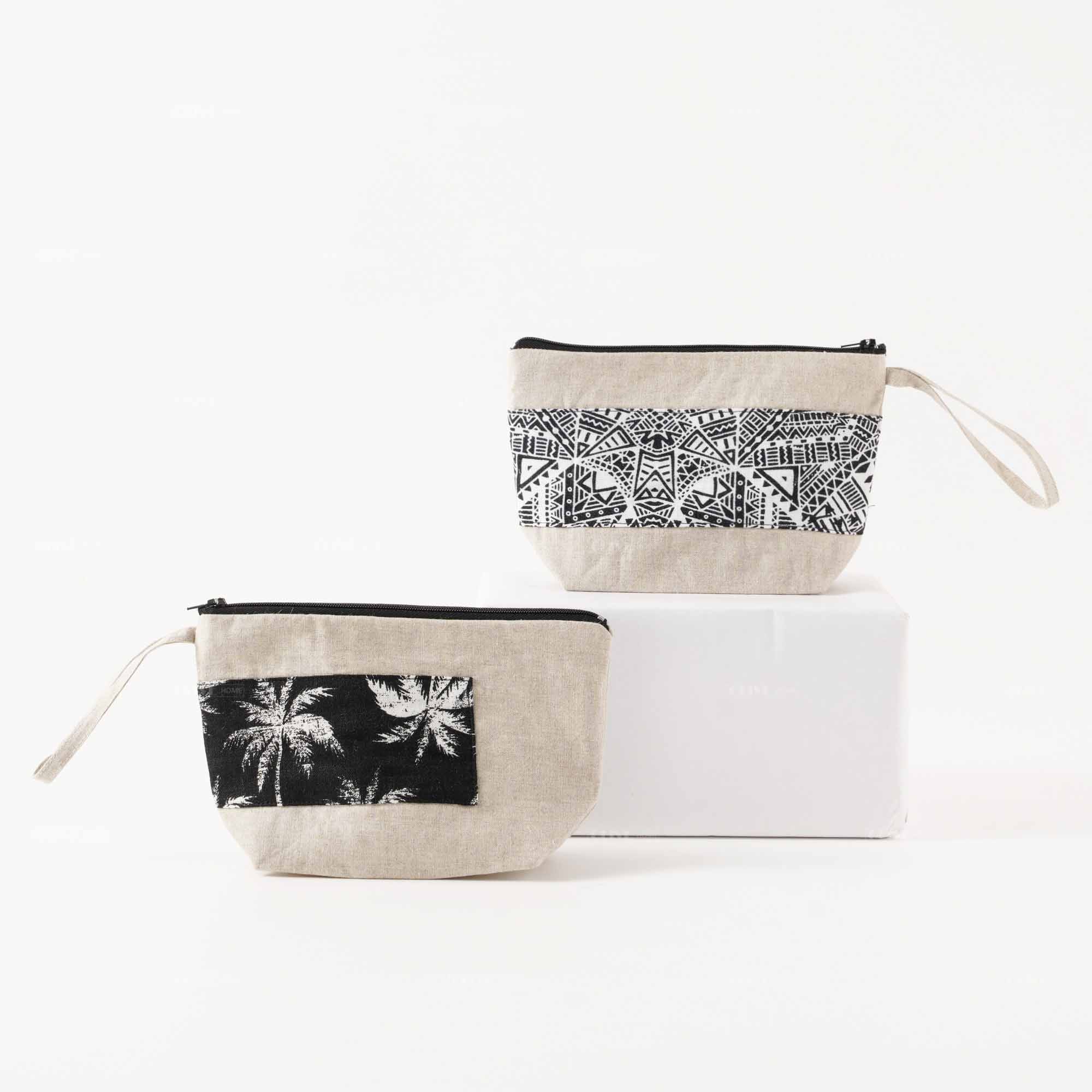 Two styles of custom linen clutch bags with handle, featuring tropical palm tree and geometric patterns, ideal for wholesale.