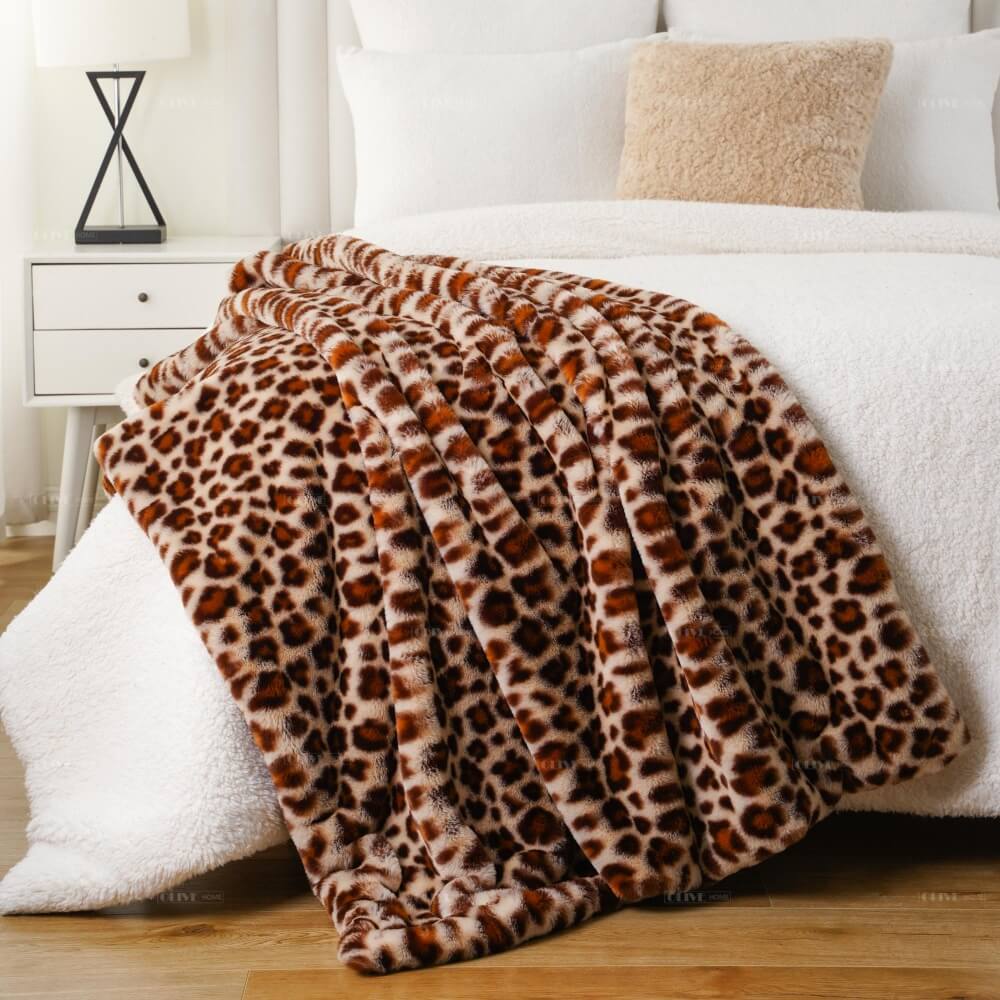 Plush leopard print cloud-like faux fur blanket styled as a bed throw, perfect for premium boutique retailers and bedding suppliers.
