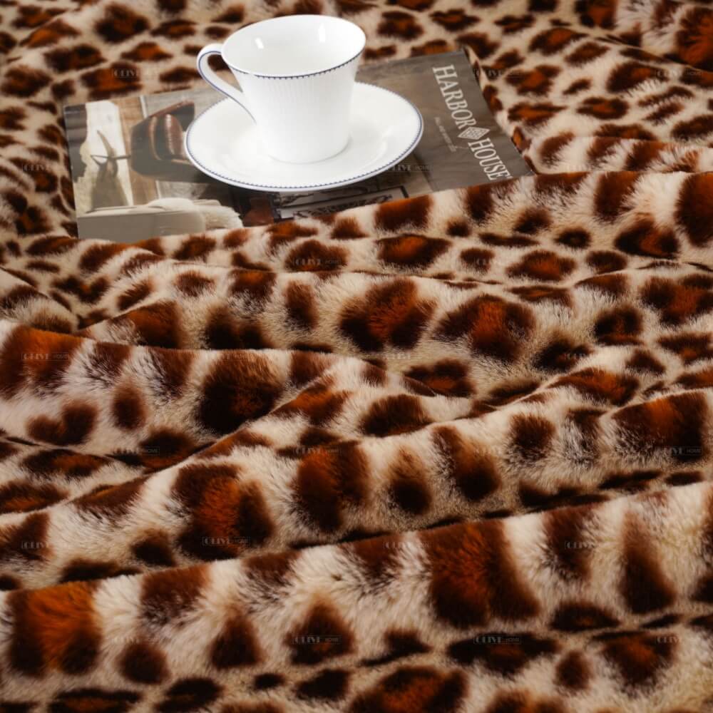 cloud like faux fur blanket 7 A white coffee cup and book on a luxury leopard print cloud-like faux fur blanket, suitable for hospitality and gift market buyers.