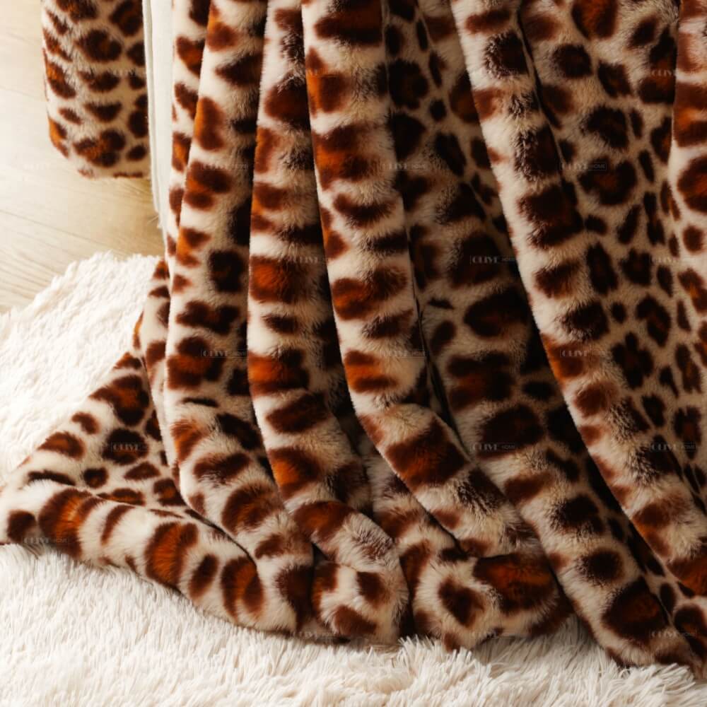 Close-up of the elegant draping and glossy fabric sheen on a cloud-like leopard faux fur blanket from an OEM textile manufacturer.